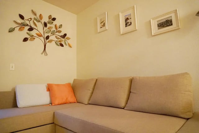 Sofa with cushions art and pictures living room at City Park Apartments in Los Angeles Student Accommodation