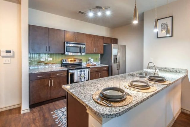 Granite countertops stainless steel appliances modern cabinets kitchen at Villas on 26th in Austin Student Accommodation