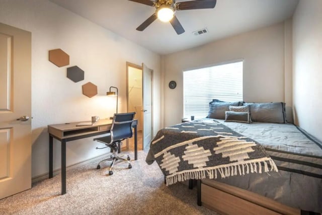 Desk chair and bed with blanket bedroom at Villas on 26th in Austin Student Accommodation