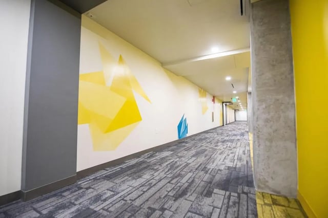 Hallway with geometric mural and grey carpet Corridor at UnionWest Student Living in Orlando Student Accommodation
