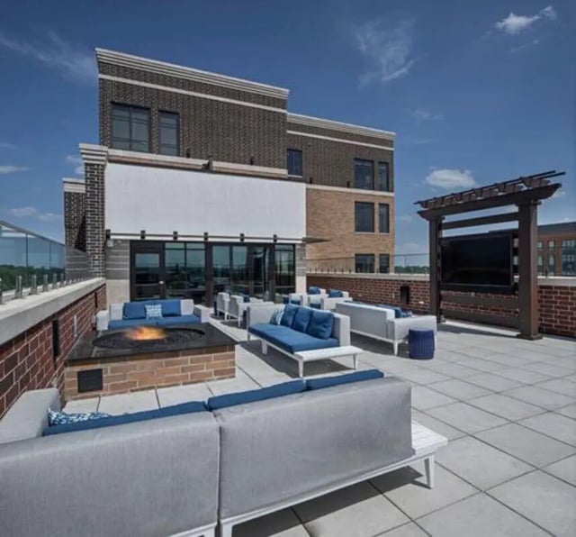 Rooftop lounge with sofas fire pit and TV Exterior at Vic Village North in Ann Arbor Student Accommodation