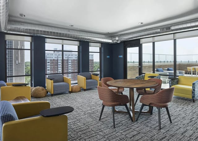 Yellow chairs round table lounge area living room at Vic Village North in Ann Arbor Student Accommodation