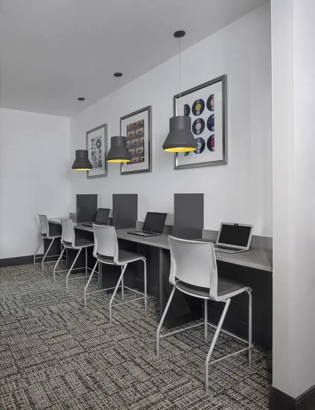 Study desks with laptops and chairs study area at Vic Village North in Ann Arbor Student Accommodation