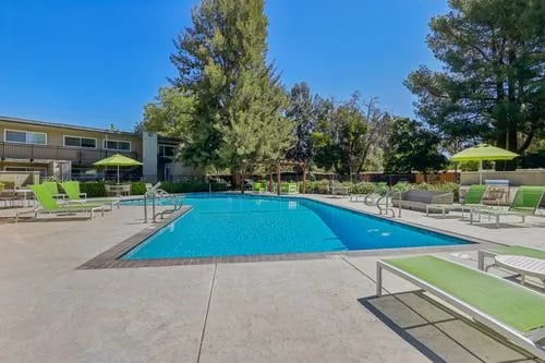 Pool with lounge chairs and umbrellas exterior at The Spoke in Davis Student Accommodation