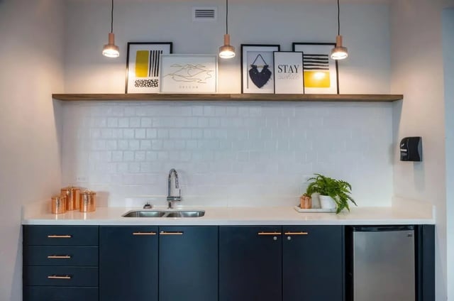 Dark cabinets sink copper jars art Kitchen at The Soto in Eugene Student Accommodation
