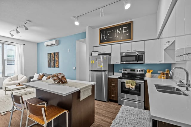 Modern kitchen living area with island and seating. at The Soto in Eugene Student Accommodation