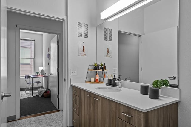 Sink vanity with mirror and open doorway beyond bathroom at The Soto in Eugene Student Accommodation