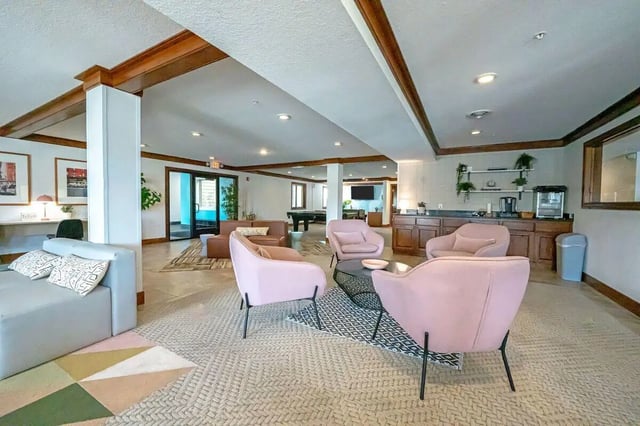 Pink chairs sofa coffee table lounge living room at The Grove at Mankato in Mankato Student Accommodation