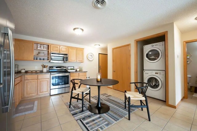 Kitchen with table chairs appliances and laundry area kitchen at The Grove at Mankato in Mankato Student Accommodation