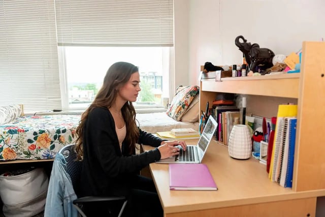 Woman on laptop near floral bed study area at The Douglas - Student Housing Apartments in Seattle Student Accommodation