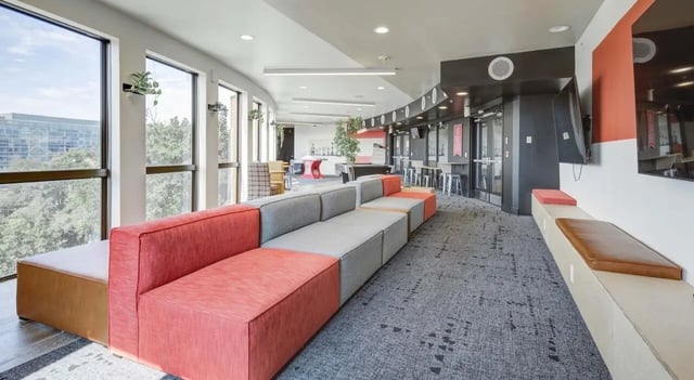 Modular sectional couch with colorful cushions and TVs living room at The Varsity College Park in College Park Student Accommodation