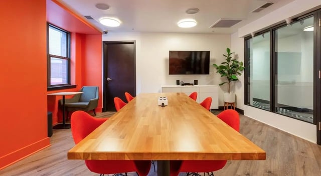 Wooden table red chairs television modern meeting room at The Varsity College Park in College Park Student Accommodation