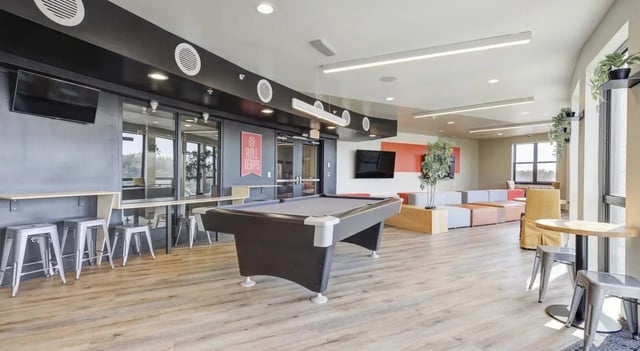 Pool table bar stools and lounge seating common area at The Varsity College Park in College Park Student Accommodation