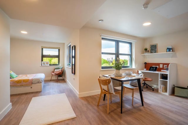 Bed desk dining table and chairs bedroom living area at Valerian in York Student Accommodation
