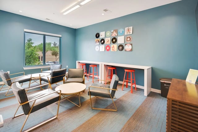 Chairs tables bar stools records wall art lounge area at The Bloc in Lubbock Student Accommodation