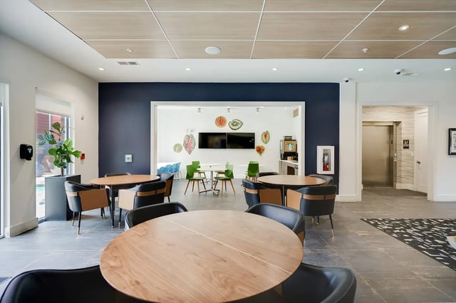 Tables chairs plant and artwork communal area at The Bloc in Lubbock Student Accommodation