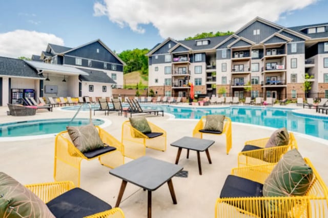 Yellow chairs pool and apartment buildings exterior at The Husk and The Helm in Cullowhee Student Accommodation