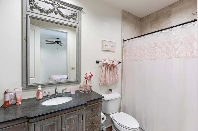 Vanity sink and toilet with floral shower curtain bathroom at The Cottages at Hooper Hollow in Oxford Student Accommodation