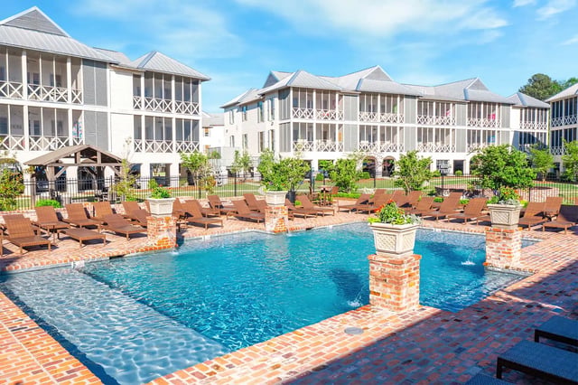 Apartment buildings with screened balconies and pool exterior at The Cottages at Hooper Hollow in Oxford Student Accommodation
