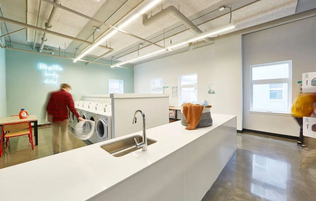 Washing machines sink and neon sign Laundry Room at Stateside in Bellingham Student Accommodation