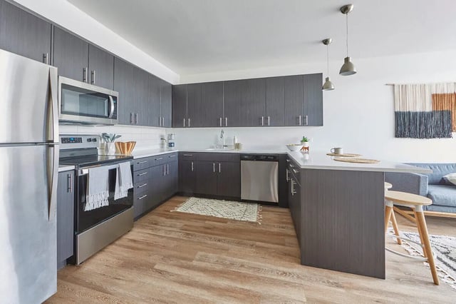 Modern kitchen with dark gray cabinets refrigerator and island kitchen at Stateside in Bellingham Student Accommodation