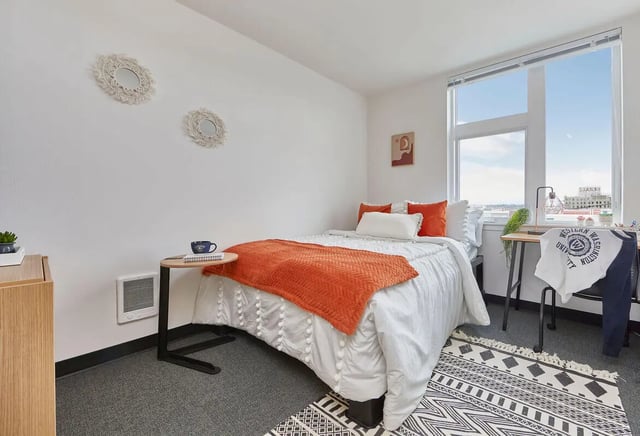 Bed with orange throw rug and desk area Bedroom at Stateside in Bellingham Student Accommodation