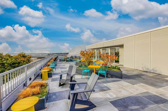 Chairs tables plants on rooftop patio exterior at Stateside in Bellingham Student Accommodation