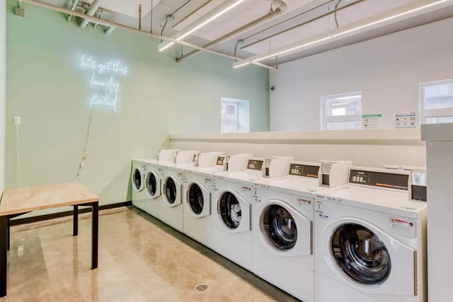 Neon sign above row of washing machines laundry area at Stateside in Bellingham Student Accommodation