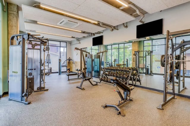 Weight machines dumbbells benches and gym equipment fitness area at Stateside in Bellingham Student Accommodation