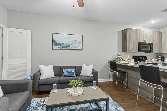 Sofa coffee table and kitchen island living room at Remerton Mill Apartments in Valdosta Student Accommodation