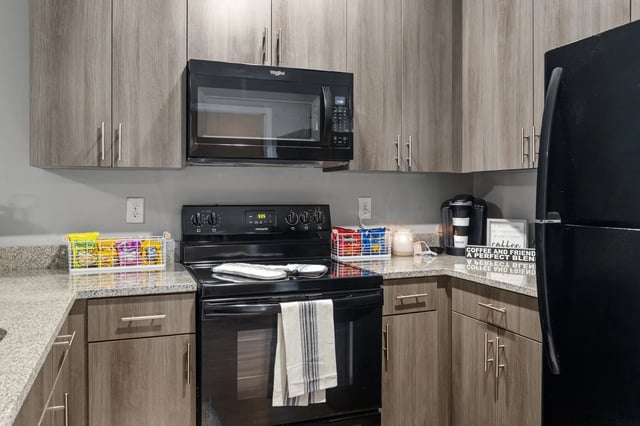 Microwave oven stove coffee maker and fridge kitchen at Remerton Mill Apartments in Valdosta Student Accommodation