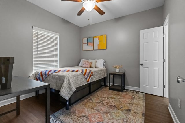 Bed desk ceiling fan abstract art bedroom at Remerton Mill Apartments in Valdosta Student Accommodation