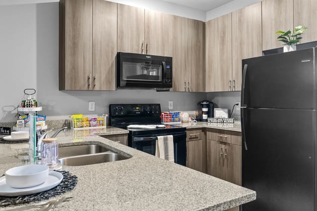 Kitchen with sink stove microwave and refrigerator kitchen at Remerton Mill Apartments in Valdosta Student Accommodation