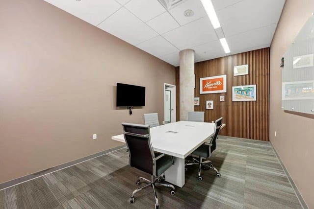 Table chairs and television in meeting room at Slate at 901 in Knoxville Student Accommodation