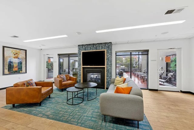 Sofa fireplace art and chairs living room at Slate at 901 in Knoxville Student Accommodation