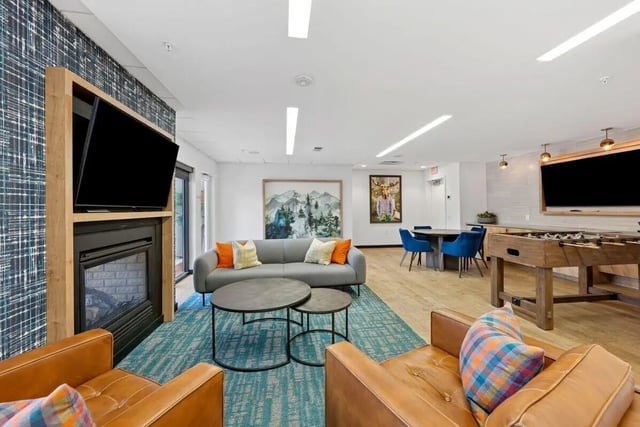 Leather chairs gray sofa foosball table living room at Slate at 901 in Knoxville Student Accommodation