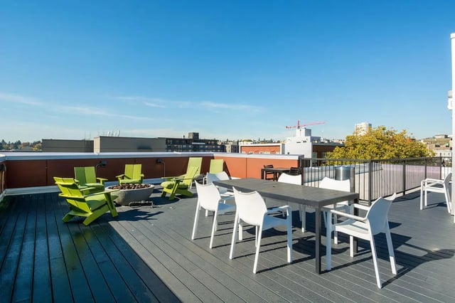 Rooftop deck with chairs tables and fire pit outdoor area at NORA Apartments in Seattle Student Accommodation