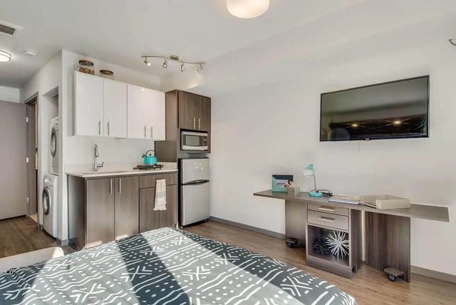 Bed washer dryer kitchen desk living room at NORA Apartments in Seattle Student Accommodation
