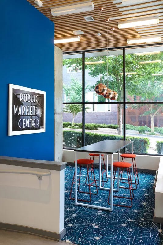 High table four red stools geometric carpet communal area at NORA Apartments in Seattle Student Accommodation