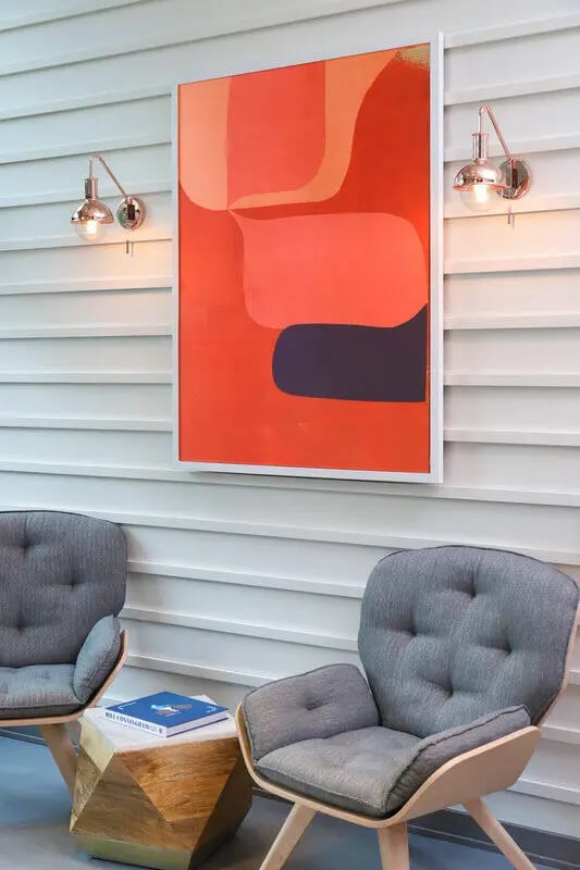 Modern artwork on wall with two gray armchairs living room at NORA Apartments in Seattle Student Accommodation