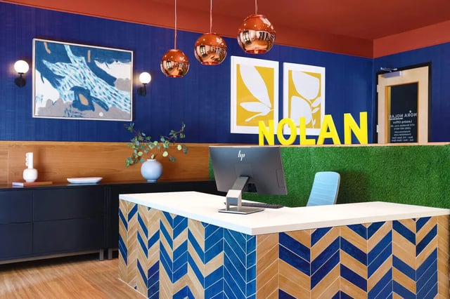 Reception desk with computer and blue chevron front desk reception at NOLAN Apartments in Seattle Student Accommodation
