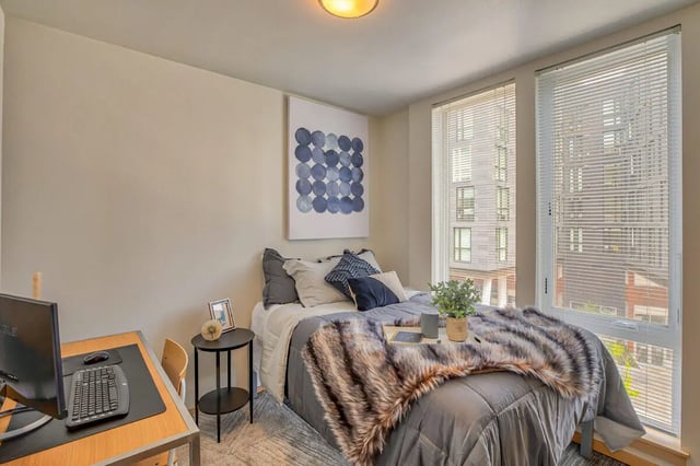 Bed with fur throw desk and computer Bedroom at NOLAN Apartments in Seattle Student Accommodation