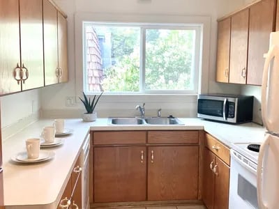 Kitchen with cups sink microwave and cabinets Kitchen at Haven White Apartments in Rexburg Student Accommodation