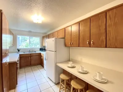 Kitchen with refrigerator cabinets counter stools and table kitchen at Haven White Apartments in Rexburg Student Accommodation