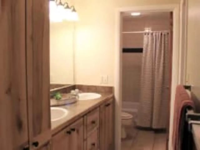 Double vanity sink wooden cabinets shower curtain bathroom at Haven Red Apartments in Rexburg Student Accommodation