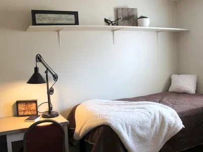 Desk lamp bed chair shelf decor bedroom at Haven Red Apartments in Rexburg Student Accommodation