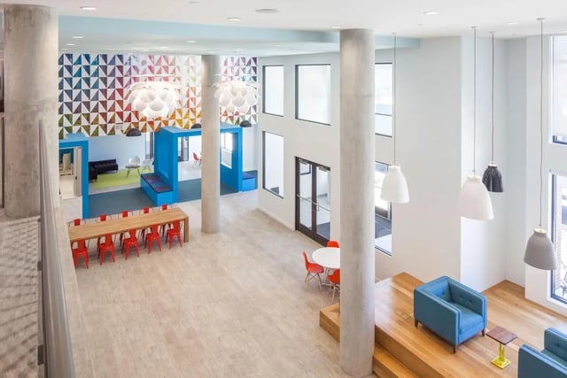 Dining area with red chairs and colorful wall lounge area. at Landmark Apartments in College Park Student Accommodation
