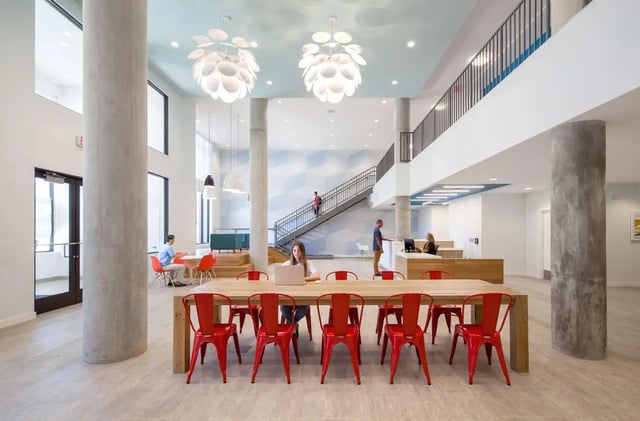 Large communal table with red chairs study area at Landmark Apartments in College Park Student Accommodation