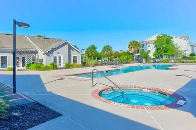 Jacuzzi and swimming pool with apartment buildings exterior at Stadium Suites in Columbia Student Accommodation