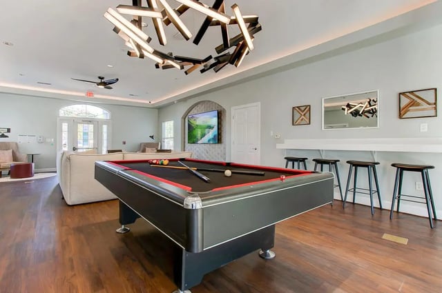 Pool table with balls cues and stools living room at Stadium Suites in Columbia Student Accommodation